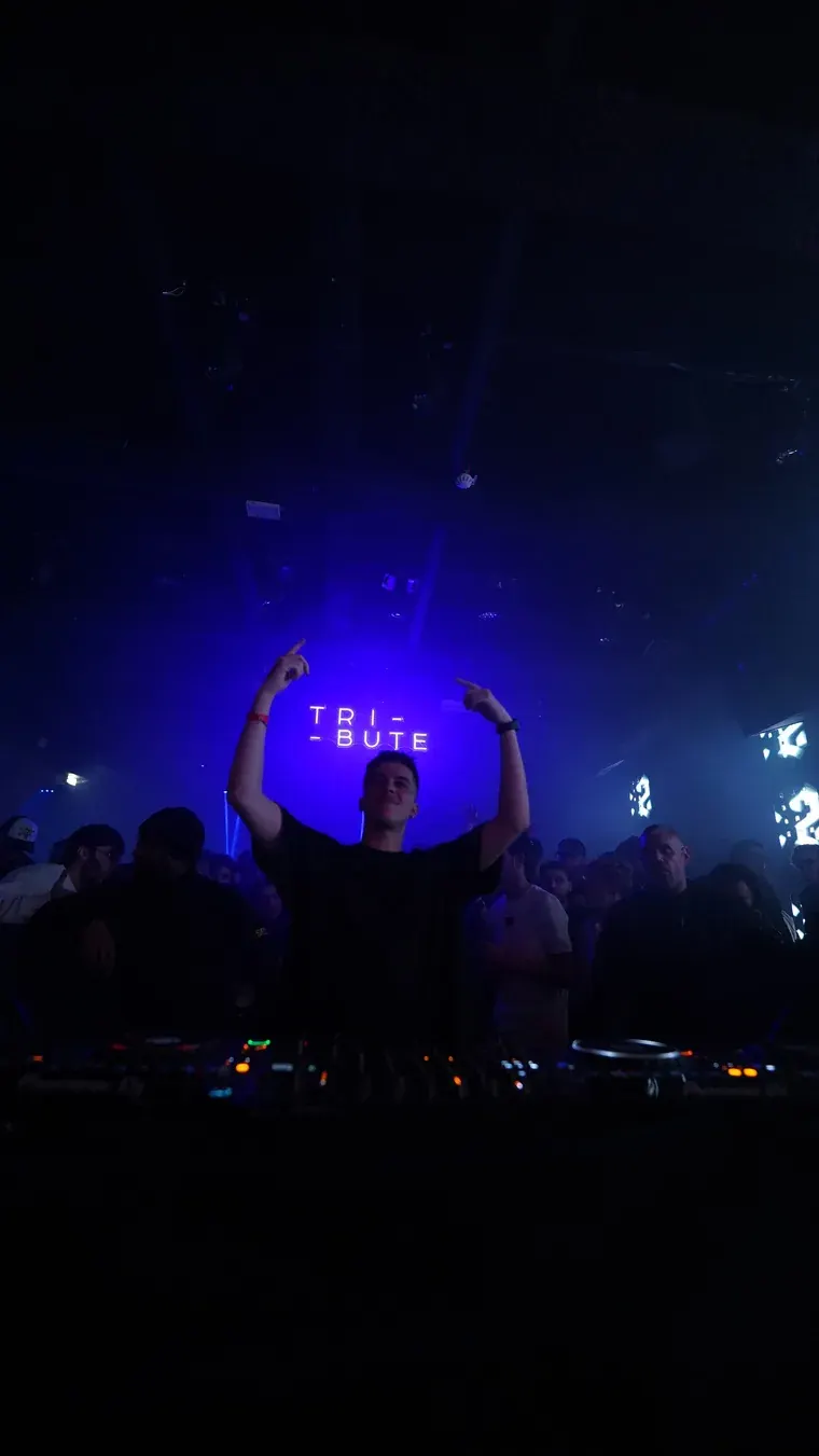 DJ under the Tribute sign, blue light