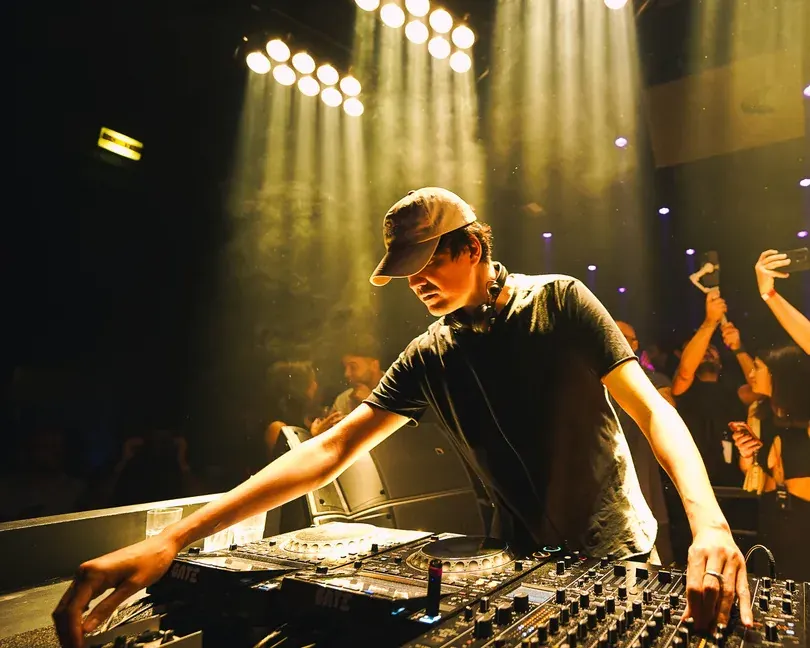 DJ at the decks in golden light