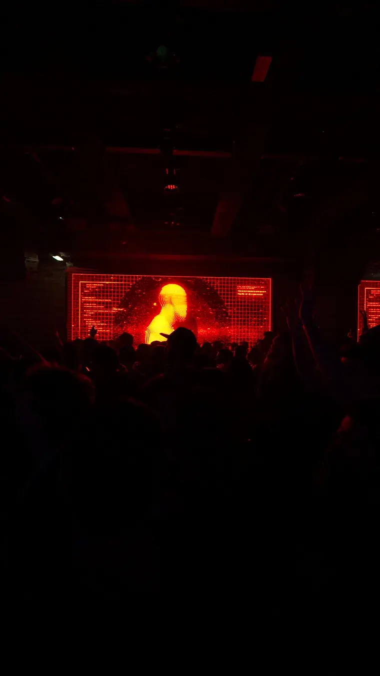 Red-lit stage screen in a dark room