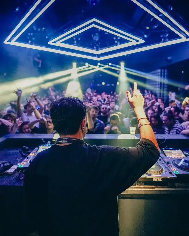 DJ facing the crowd under blue diamond lights