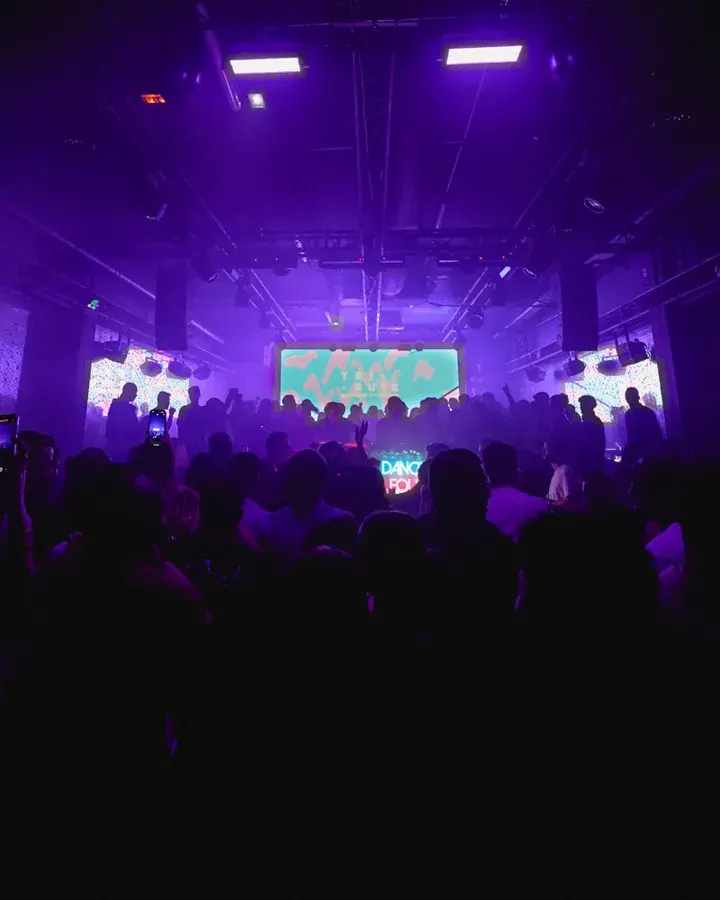 Crowd facing a violet LED wall